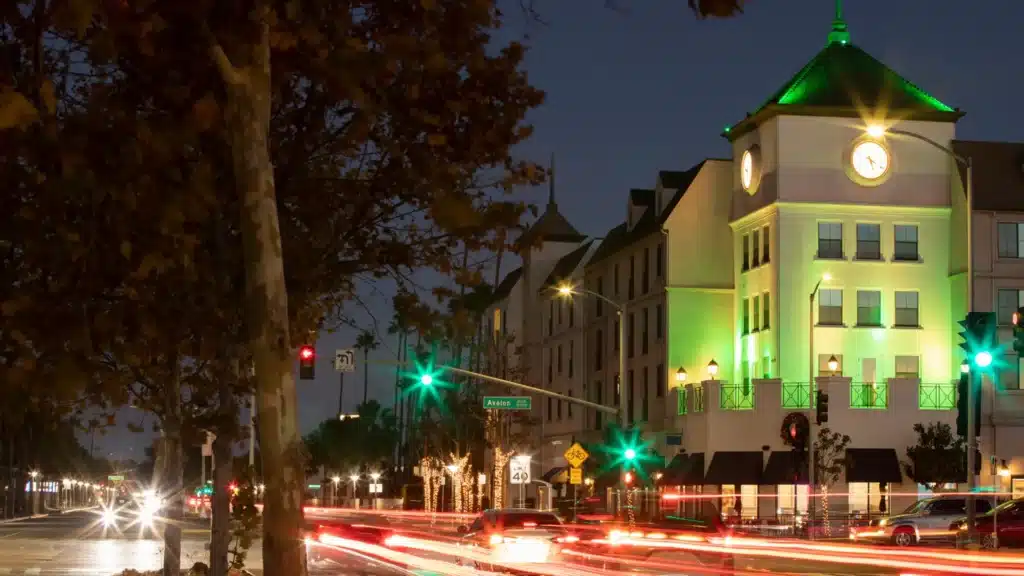 Injured driver standing beside damaged car after crash in Carson California.